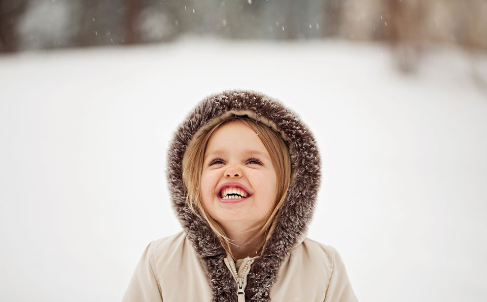 young girl watching snow fall