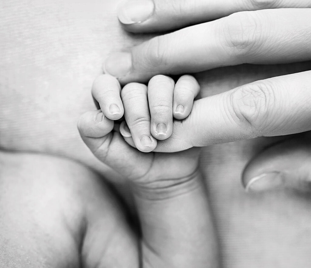 Baby holding mother's finger; Black and white Newborn photo by Newmarket Newnborn Photographer
