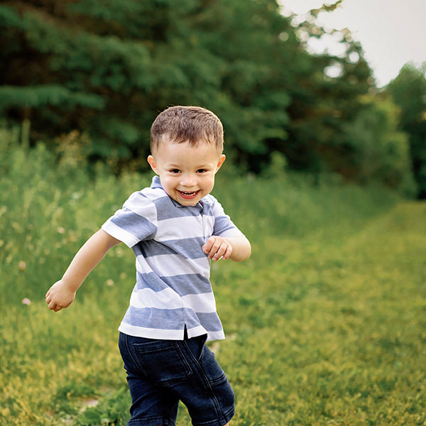 Young boy looking back as he runs, fun family photoshoot